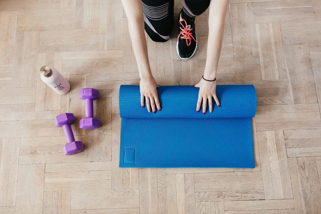 Ženska zvija podlogo za pilates in druge vadbe