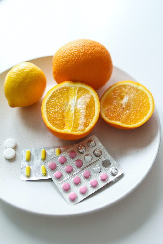Slika krožnika pomaranč in limon z kapsulami vitamina C